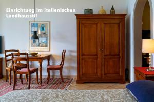 1 dormitorio con mesa, sillas y armario de madera en TOP-Ferienwohnung im Landhausstil mit Panoramablick & Pool, en Vira