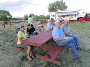 eine Gruppe von Menschen, die um einen Picknicktisch sitzen in der Unterkunft Ute Bluff Lodge, Cabins and RV park in South Fork
