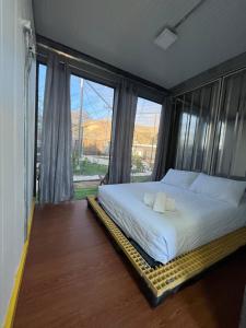 a bedroom with a bed and a large window at Pupa House in Tamarindo