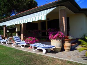 a group of chairs sitting on a patio with flowers at Appartamenti Pian d'Alma in Punta Ala