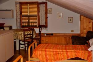 a bedroom with a bed and a table and a kitchen at Appartamenti Pian d'Alma in Punta Ala