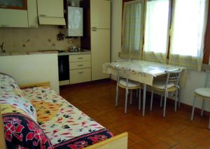 a kitchen with a table and chairs in a room at Appartamenti Pian d'Alma in Punta Ala