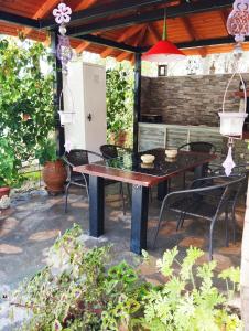 a wooden table and chairs on a patio at Stella's Apartment in Áyios Pávlos