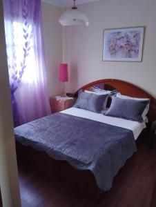 a bedroom with a large bed with a blue blanket at Stella's Apartment in Áyios Pávlos