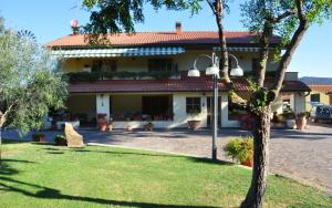 a large white house with a red roof at Appartamenti Pian d'Alma in Punta Ala