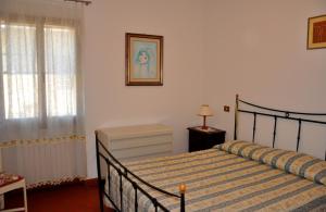 a bedroom with a bed and a window at Appartamenti Pian d'Alma in Punta Ala