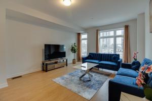 a living room with blue couches and a tv at Brand new townhouse, 30 minutes to Downtown in Toronto