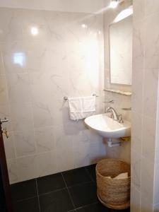 La salle de bains blanche est pourvue d'un lavabo et d'un miroir. dans l'établissement Avenida Premium: Confort y Vistas Excepcionales, à San Salvador de Jujuy