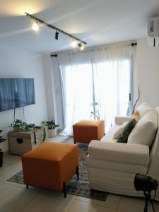 a living room with a couch and two chairs and a tv at Avenida Premium: Confort y Vistas Excepcionales in San Salvador de Jujuy