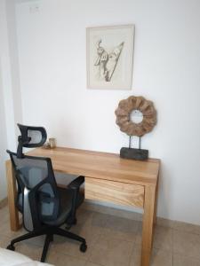 a wooden desk with a chair and a clock on it at Avenida Premium: Confort y Vistas Excepcionales in San Salvador de Jujuy