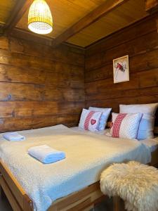 a bed in a wooden cabin with towels on it at Mała Bawaria in Zakopane