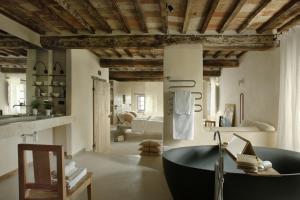 baño con bañera negra en el medio de una habitación en Monteverdi Tuscany, en Castiglioncello del Trinoro