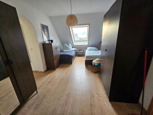 um corredor com um quarto com duas camas e um piso de madeira em StayInn Delitzsch Apartment für bis zu 6 Personen em Delitzsch