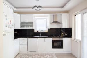 a kitchen with white cabinets and a ceiling fan at Villa Kaylem in Dalyan