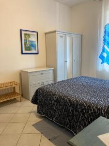 a bedroom with a bed and a dresser and a cabinet at Aroma Di Mare in Lido di Ostia