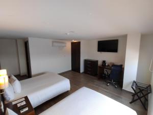 a hotel room with a bed and a television at Ramada by Wyndham Tampico Centro in Tampico