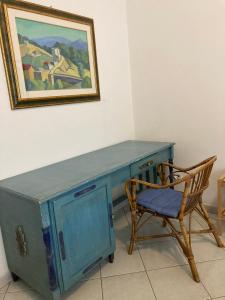 einem blauen Schreibtisch mit einem Stuhl und einem Gemälde an der Wand in der Unterkunft Aroma Di Mare in Lido di Ostia