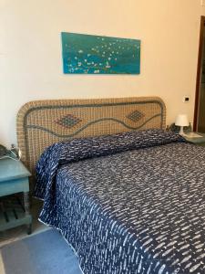Schlafzimmer mit einem Bett mit blauer Decke in der Unterkunft Aroma Di Mare in Lido di Ostia