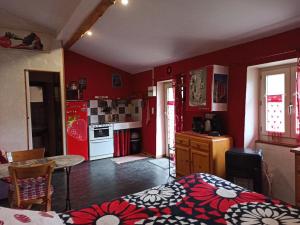 a kitchen with red walls and a bed in a room at Gîte du Château de Retourtour in Lamastre