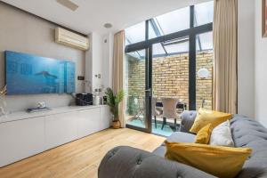 a living room with a couch and a large window at 2 bed arty flat at Trafalgar Square in London