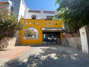 a yellow building with a gate in front of it at Habitación doble Hotel Chapultepec-Americana in Guadalajara