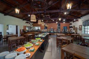 uma sala de jantar com mesas e cadeiras com tigelas de comida em Recanto Alvorada Eco Resort em Brotas