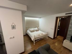 a bedroom with a bed with white sheets and pillows at Merc Porto Santa Catarina in Porto