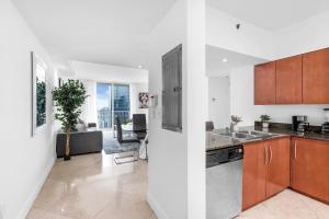 een keuken met een wastafel en een woonkamer bij Spacious 2 Bed Unit in Brickell with Free Parking in Miami