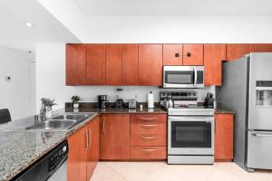 een keuken met houten kasten en roestvrijstalen apparatuur bij Spacious 2 Bed Unit in Brickell with Free Parking in Miami