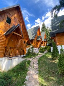a log home with a pathway leading to the front door at ZlatAir Eco Chalet in Nova Varoš