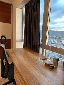 an office with a wooden desk with a large window at Avenida Premium: Confort y Vistas Excepcionales in San Salvador de Jujuy
