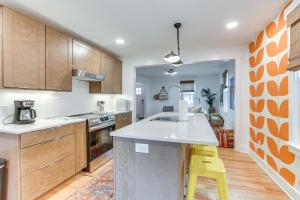 a kitchen with wooden cabinets and a yellow stool at Danville Rental, Walk to Caesars Virginia Casino in Danville