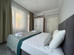 1 dormitorio con 1 cama grande y 2 almohadas en KAĞAN Holiday Apartments, en Kemer