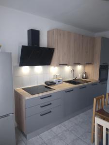 a kitchen with white cabinets and a sink and a stove at Apartman Maja in Veli Iž
