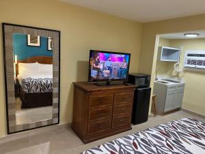 een slaapkamer met een televisie op een dressoir met een bed bij Royal Inn in Kenedy