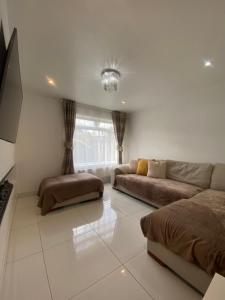 a white living room with a couch and a window at 3 Bedroom House in Northampton