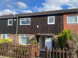 a brick house with a wooden fence at 3 Bedroom House in Northampton