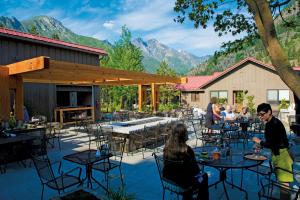 un groupe de personnes assises à des tables sur un patio dans l'établissement Sleeping Lady Mountain Resort, à Leavenworth