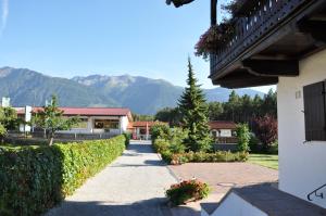 a pathway leading to a house with mountains in the background at Gästehaus Mayer in Mieming