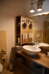 W łazience znajduje się biała umywalka i lustro. w obiekcie Parkhotel Langenthal w mieście Langenthal
