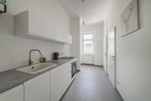 une cuisine blanche avec des armoires blanches et un évier dans l'établissement spacious studio in vienna, à Vienne