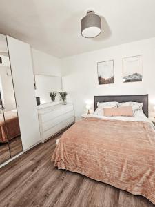 een witte slaapkamer met een bed en een grote spiegel bij Modernes Appartment im Grünen in Witten