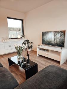 a living room with a large flat screen tv at Modernes Appartment im Grünen in Witten