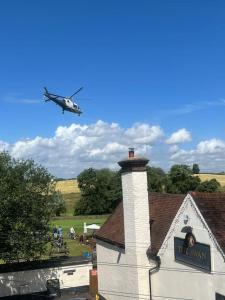 a helicopter flying over a house with a church at The Cottage, with Superking bed & private patio in Chaddesley Corbett