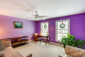 een woonkamer met paarse muren en een bureau bij Colorful Milford Home on 7 Wooded Acres! in Milford