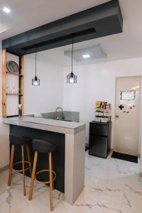 cocina con fregadero y 2 taburetes en Hideout Airbnb, en Pandi