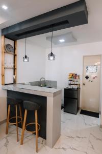 a kitchen with a sink and two bar stools at Hideout Airbnb in Pandi