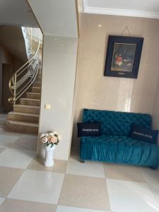 a blue couch in a room with a staircase at Diamond Hotel in Chişinău