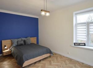 sypialnia z łóżkiem z niebieską ścianą w obiekcie Apartament nad Wisłą 2 w mieście Płock