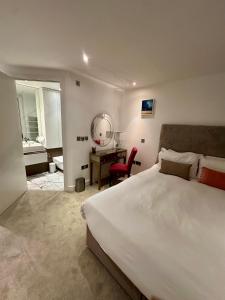 a bedroom with a large bed and a desk with a mirror at Gunwharf Quays Harbour Apartments in Portsmouth